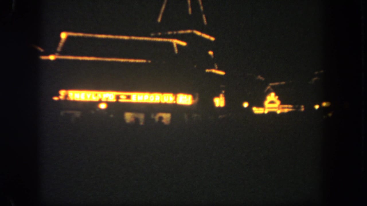 Illuminated Emporium sign and roofline glowing against a dark night sky.