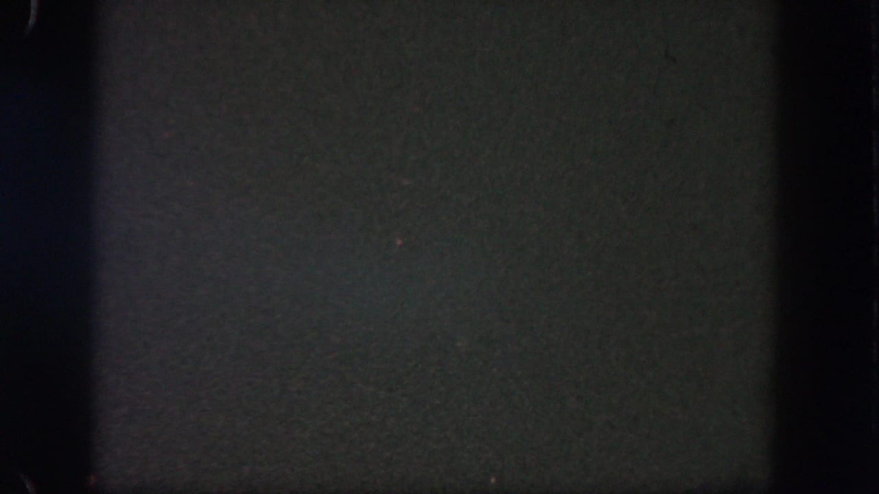 Dark night sky from 1962 Disneyland home-movie footage, with grain, low exposure, and black film-edge shadows.