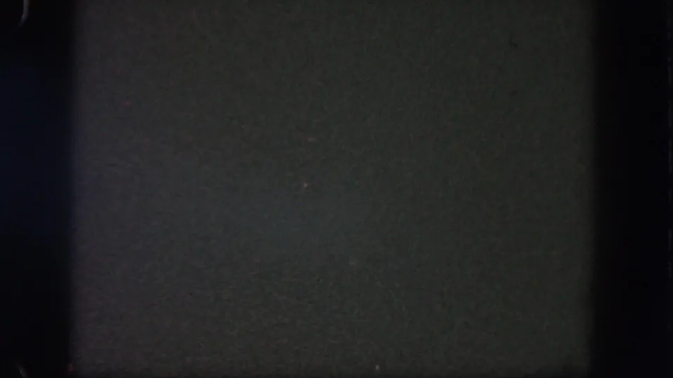 Dark night sky from 1962 Disneyland home-movie footage, with grain, low exposure, and black film-edge shadows.