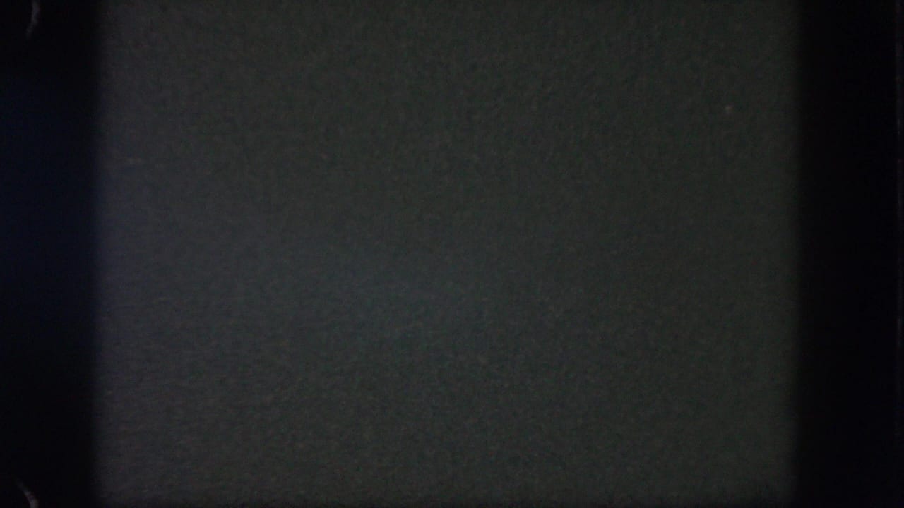 Dark 1962 8mm home-movie frame from Disneyland with faint grain, gate edges, and no identifiable people or landmarks.