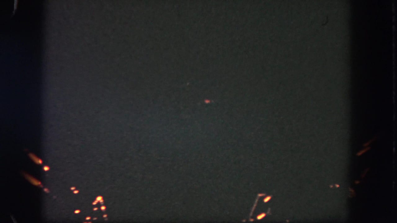 Dark sky with a few small orange fireworks sparks near the lower edge.