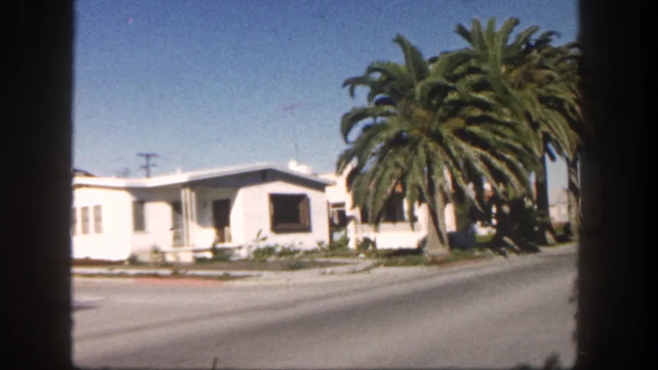The coastal drive transitions into a San Diego residential street view with a white house, large palm tree, road edge, and utility lines.