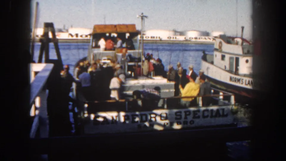 San Diego bay ferry landing in 1962 with the San Pedro Special crowded at dock and a neighboring boat marked Norm's Land visible.
