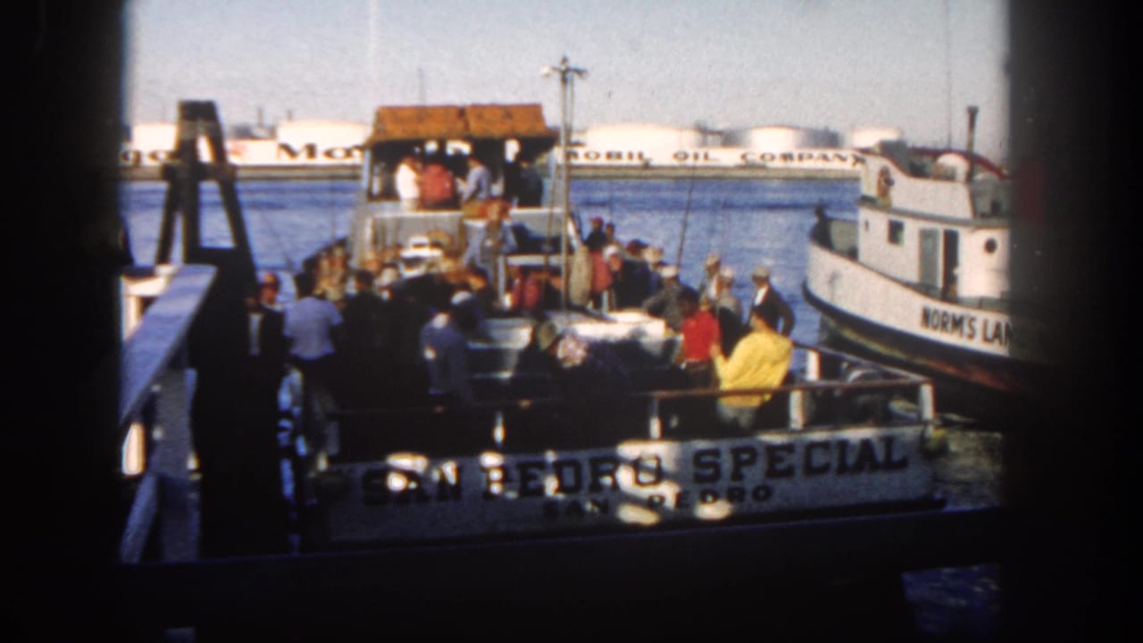 Passengers boarding a harbor boat near a vessel marked San Pedro Special.