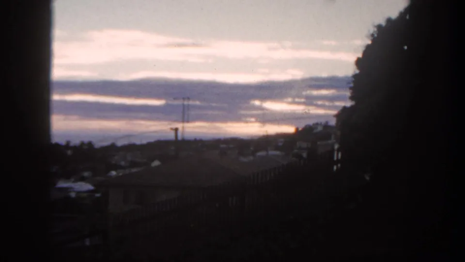 The final frame shifts to a twilight San Diego neighborhood view with rooftops, a utility pole, layered clouds, and dark hillside edges.