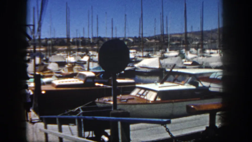 The closing frame shows the San Diego marina dock crowded with boats and masts, with a person partly visible at the edge.