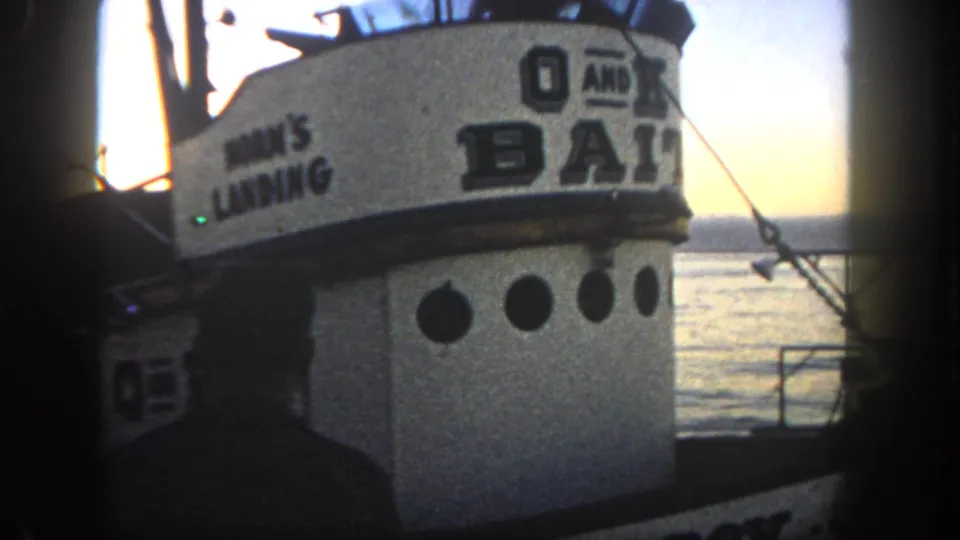 1962 San Diego 8mm view of the bait boat cabin and dockside silhouette, with HORN'S LANDING and O AND K BAIT lettering visible.