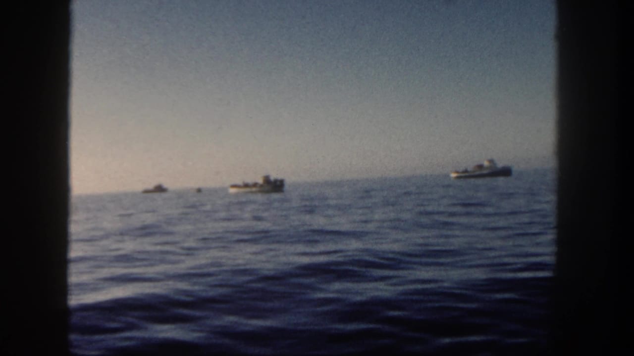 Distant small boats sit along the hazy San Diego horizon in a soft 1962 8mm ocean view.