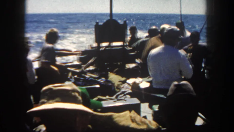 Men aboard a boat off San Diego are seen from an interior position, with equipment, hats and open ocean visible.