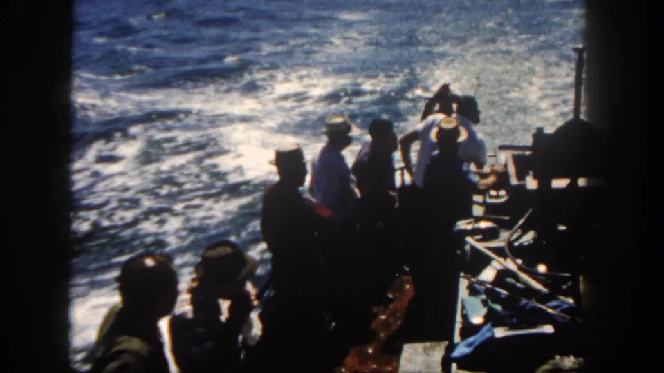 1962 San Diego 8mm frame of boat passengers watching the choppy water and wake from a crowded deck.