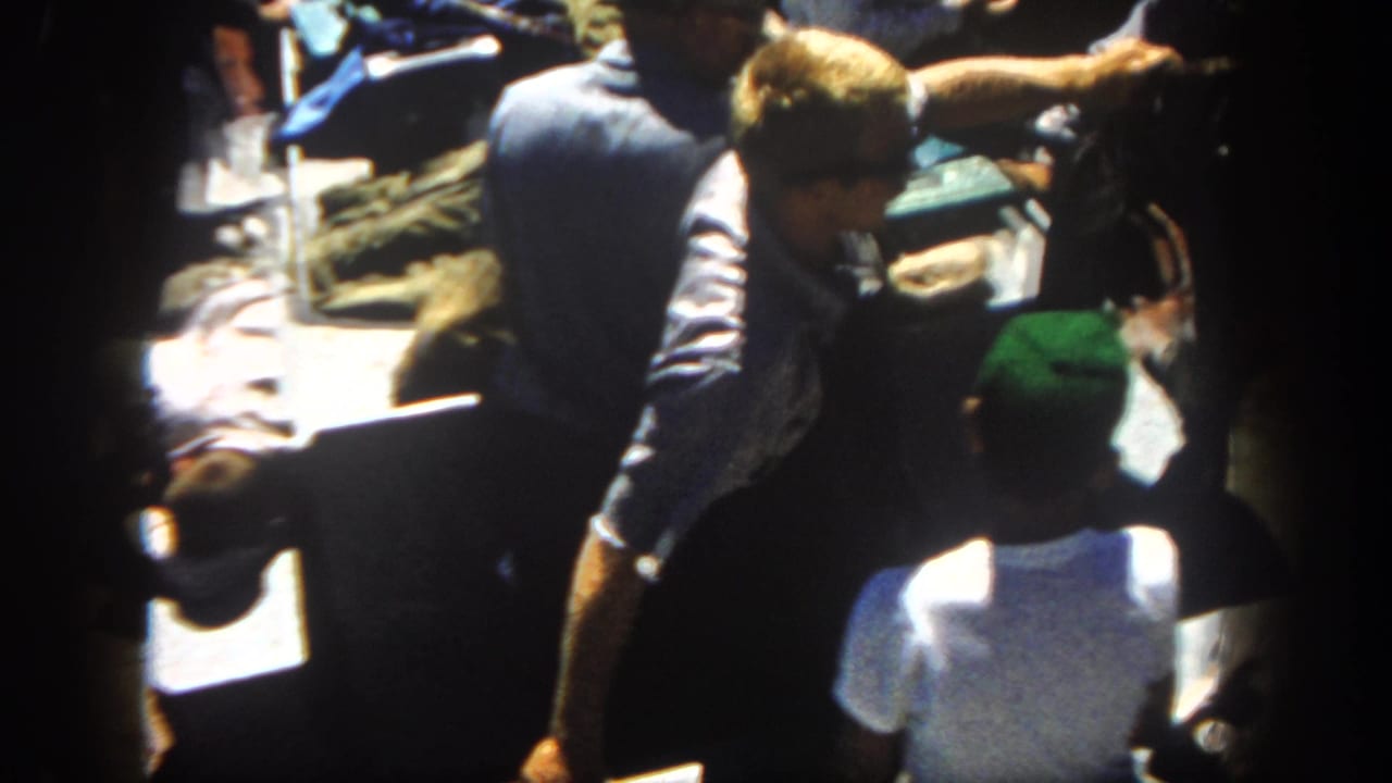 On a 1962 San Diego boat outing, a man leans over deck gear while other figures stand close by near sunlit water.