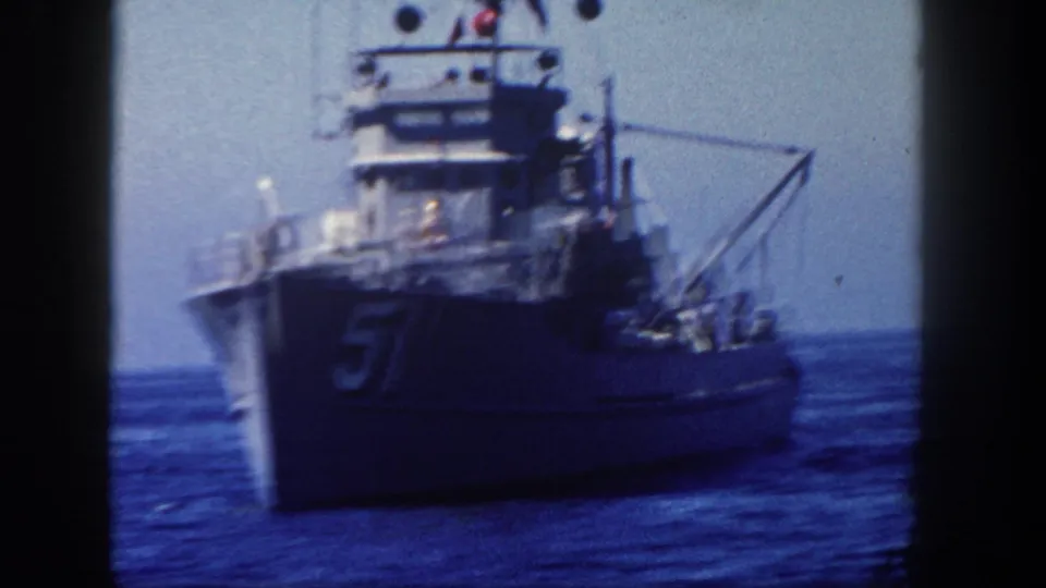 1962 San Diego 8mm frame with the bow and superstructure of naval vessel 57 filling much of the view.