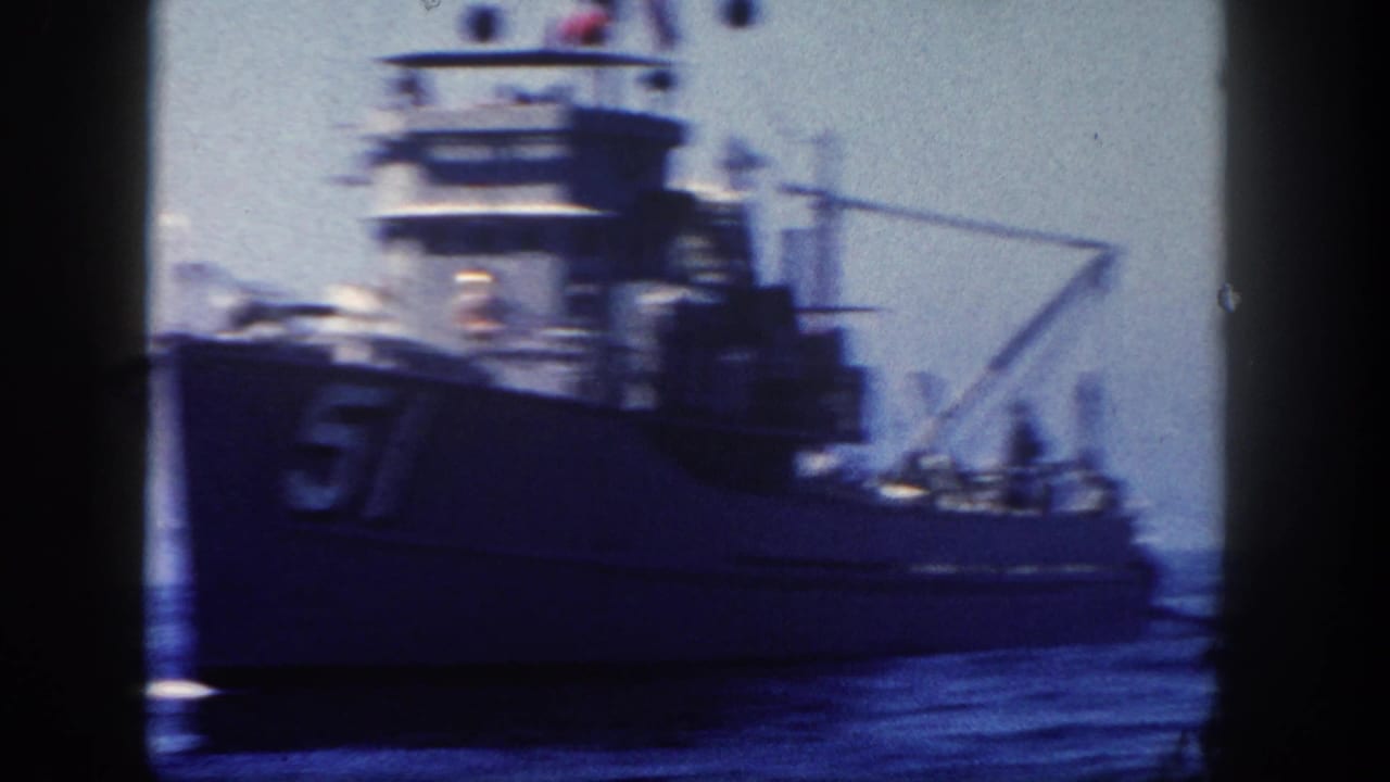 1962 8mm frame from San Diego area showing a large gray naval vessel passing on open ocean, with hull number 51 and upper deck equipment visible.