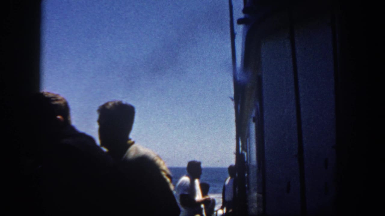 Silhouetted men stand on a ship deck looking toward the ocean horizon.