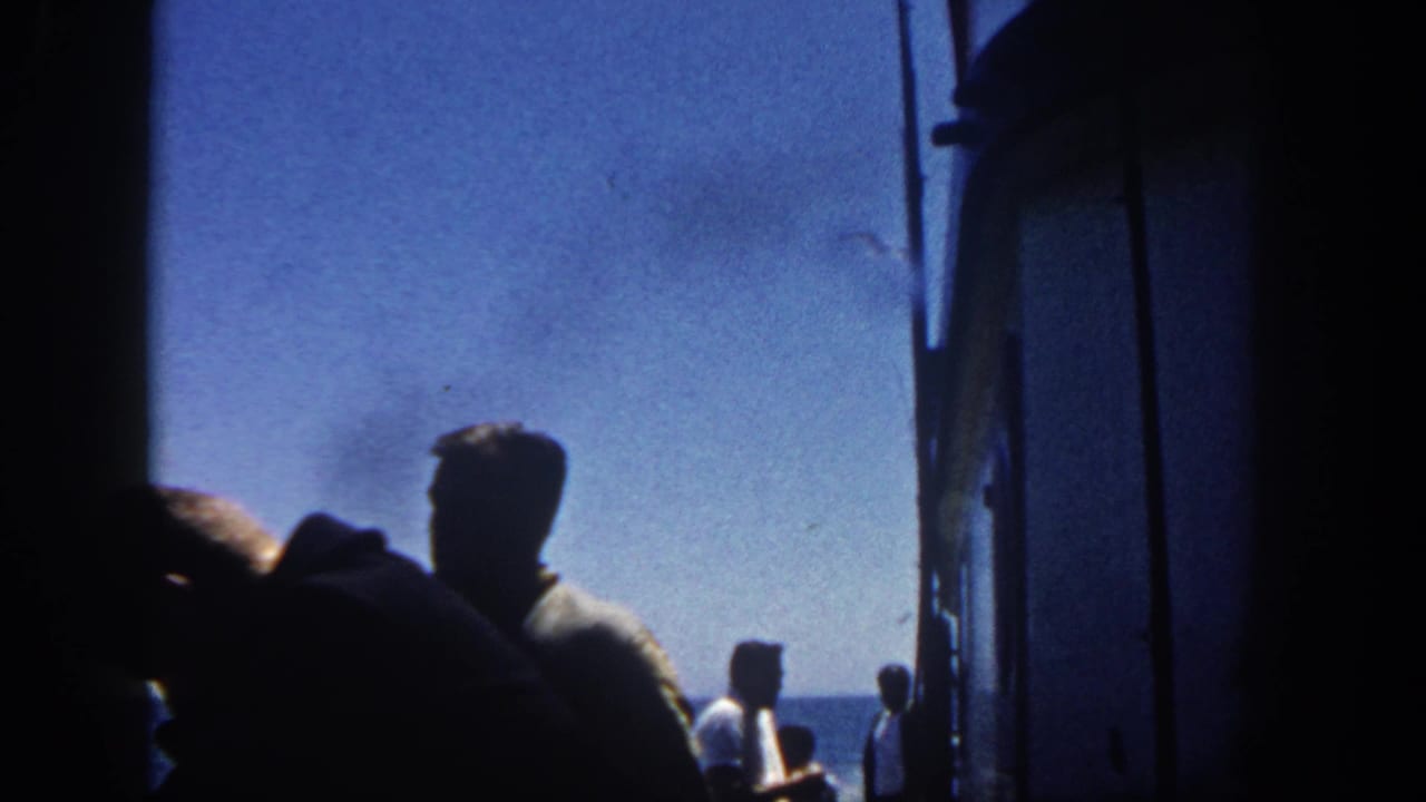 Passengers in silhouette stand near a deck opening with ocean visible beyond.