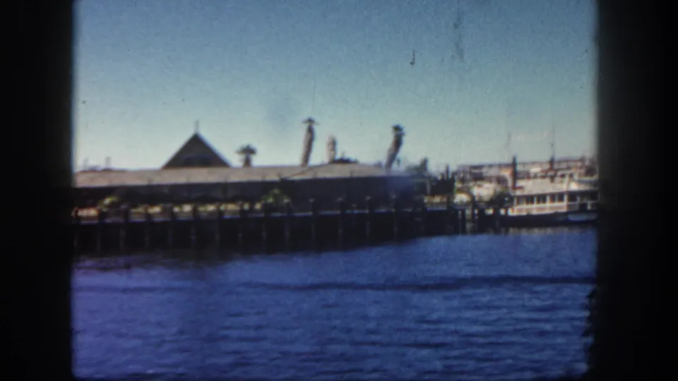 The final 8mm frame shows the San Diego pier building across harbor water, with decorative roofline elements and a boat along the right edge.