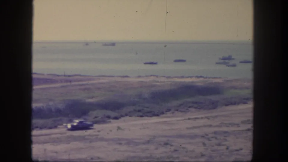 San Pedro, California, 1962 frame with a vehicle near the lower road and several large ships offshore in hazy daylight.