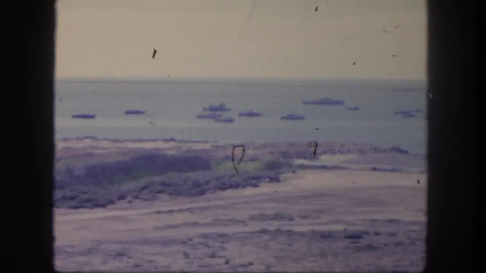 San Pedro home-movie frame from 1962 showing a wide harbor view with anchored ships, shoreline, and visible 8mm dust marks.