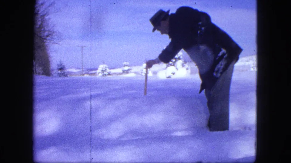 In the 1963 Proctor winter scene, the man bends over and probes the snow with a wooden stick to check its depth.