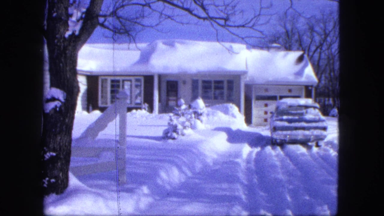 1963 Proctor, Minnesota winter exterior with a snow-laden house, partially buried car, and bare trees.
