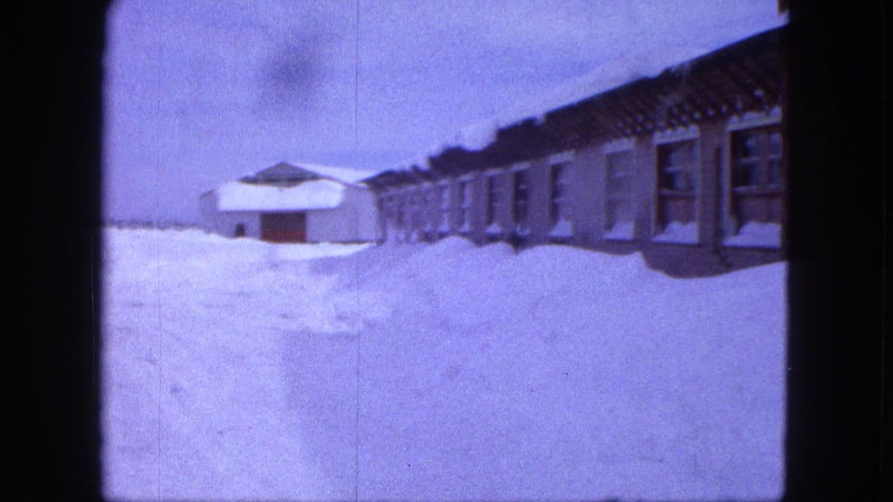 1963 Proctor, Minnesota home-movie frame showing houses partly buried by deep winter snowdrifts.