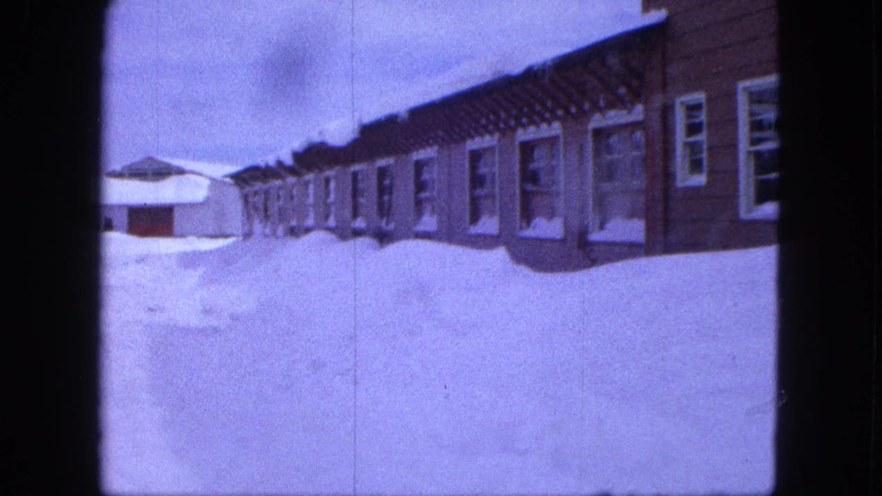 Snowbanks surround a row of Proctor, Minnesota houses in a purple-tinted 1963 8mm frame.