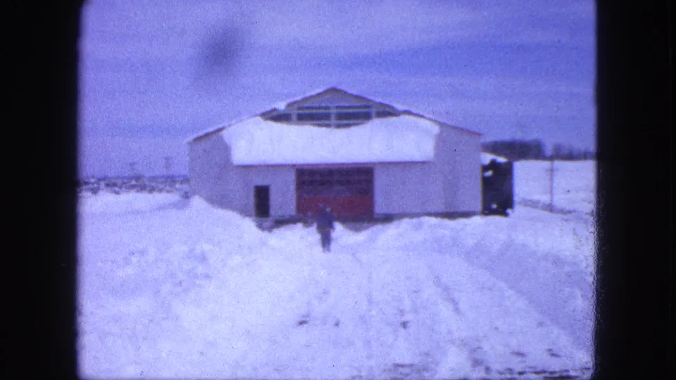 The final frame shows the small dark figure near the red door of the snow-surrounded building in 1963 Proctor, Minnesota.