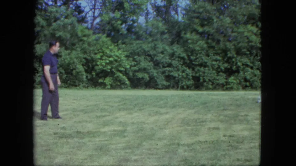 The man remains on the left side of the Saint Paul lawn after the dog has moved out of clear view.