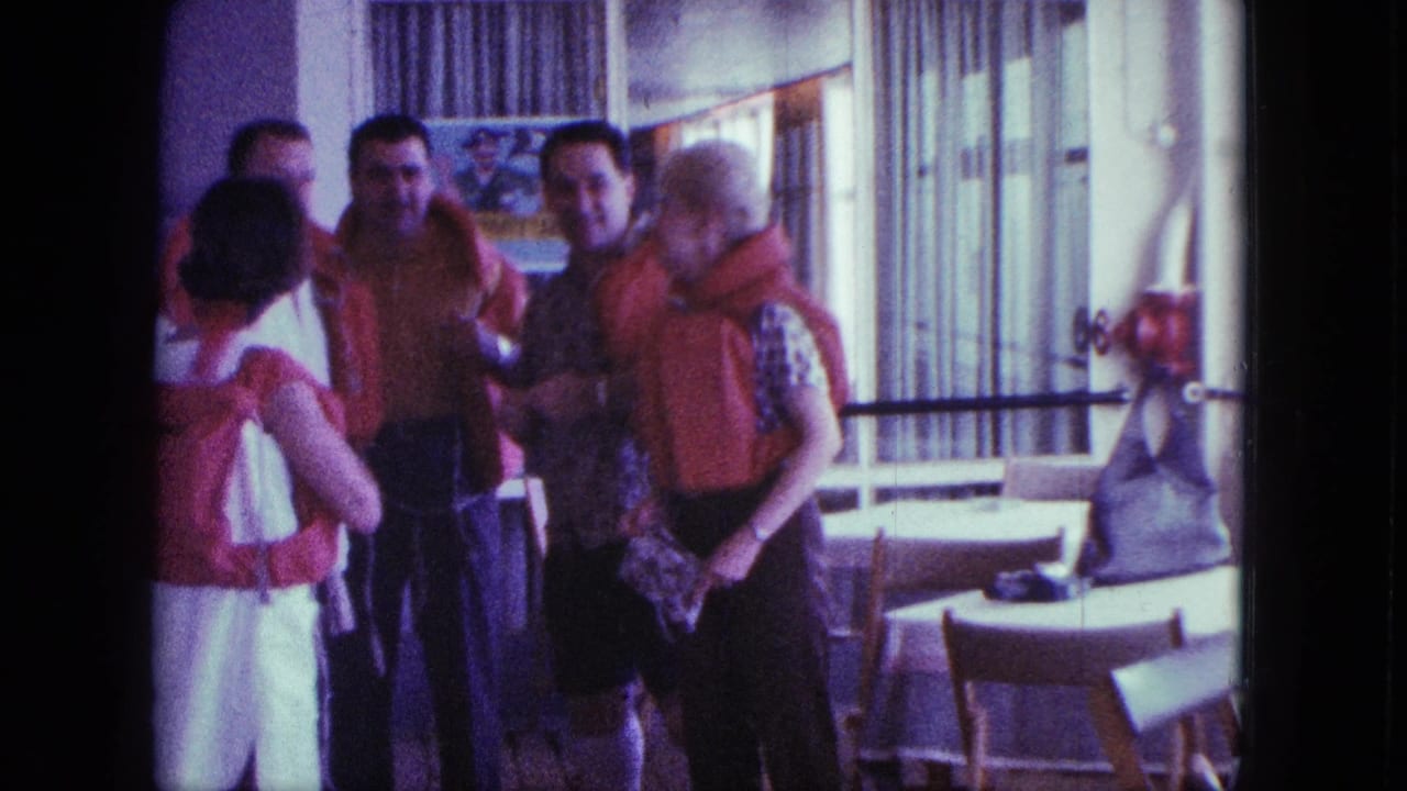 Adults wearing life jackets talk beside tables and windows.