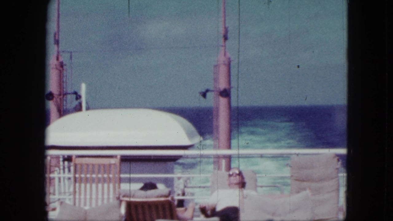 1963 San Diego boat-deck scene with a seated passenger in sunglasses, lifeboat housing, railings, and blue ocean in the background.