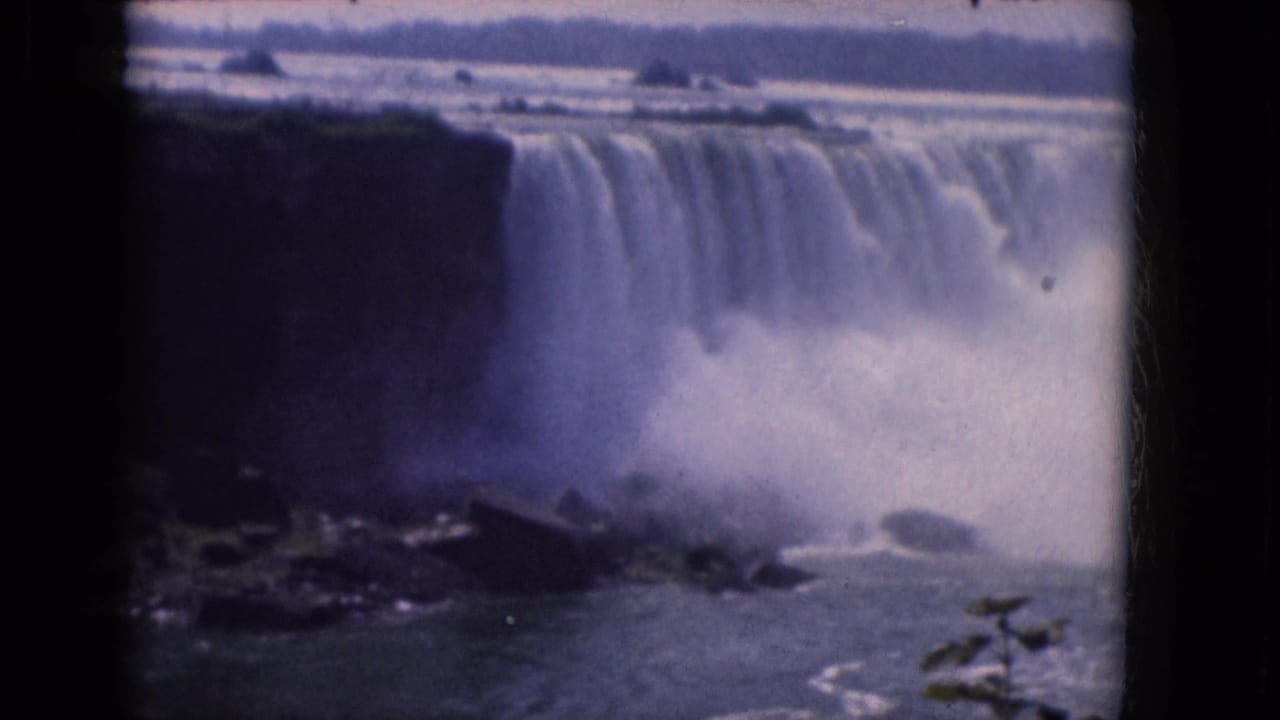 Water pours over a cliff while heavy mist rises from the base.