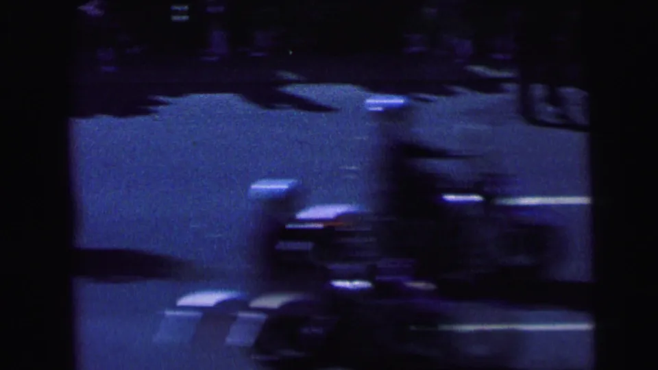 1964 Camden 8mm frame showing a dark, blurred nighttime road view with light streaks and a motorcycle-like form in motion.