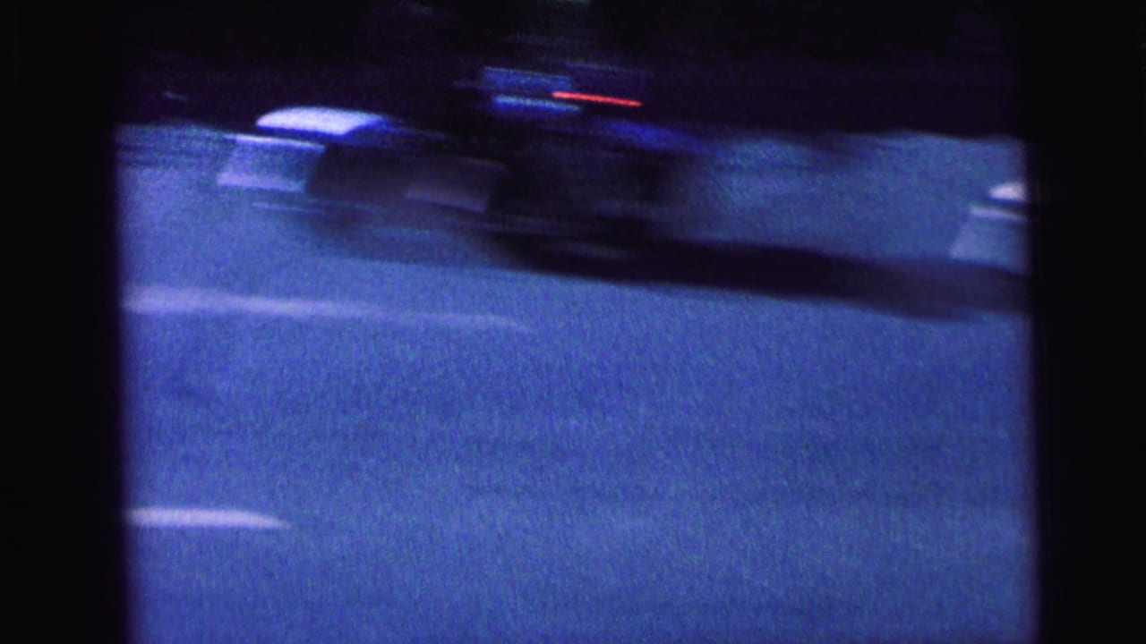 Blurred vehicle passing on a paved street with a white lane line.