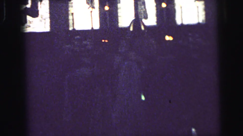 Distant 8mm view inside a Camden church, with bright windows over a largely silhouetted congregation.