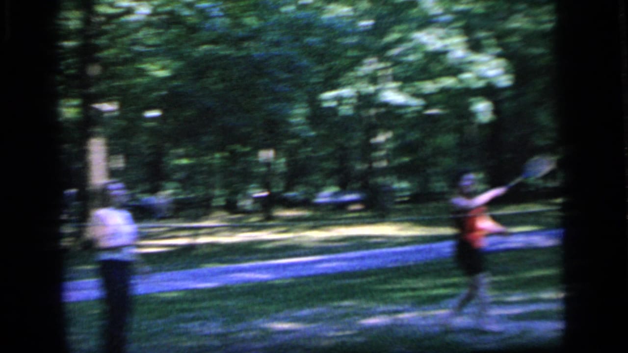 1964 Camden park footage shows a woman in red swinging a racket while another woman stands near the path.