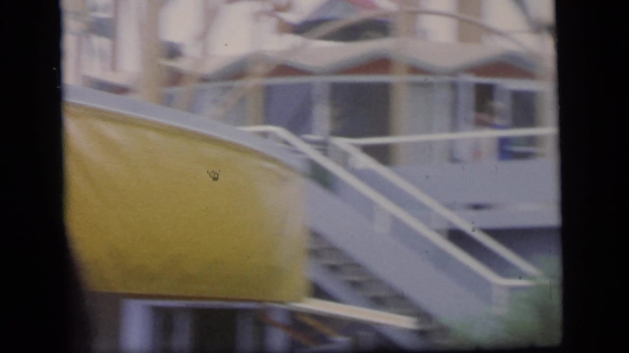 Blurred yellow curved structure beside railings and an indistinct head in the foreground.