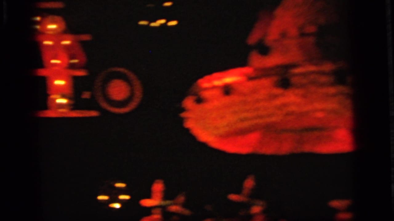 Red and yellow glowing amusement display shapes against a dark background.