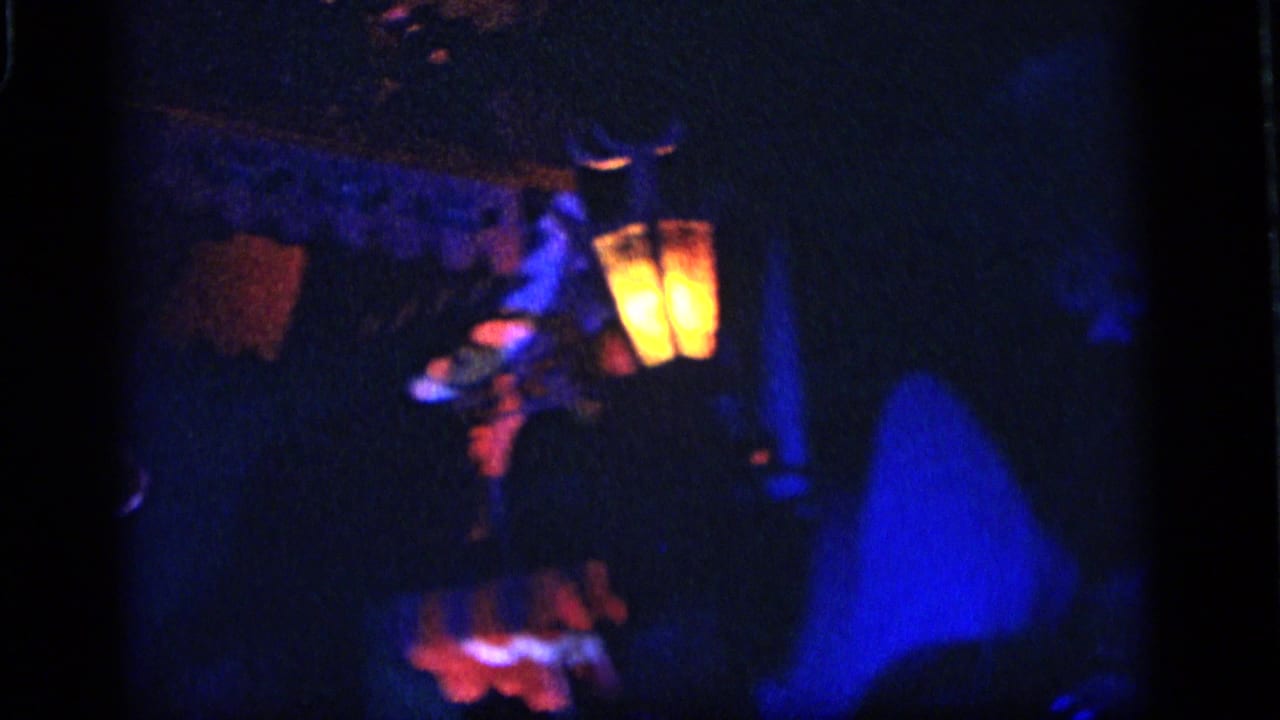 Dim attraction scene with glowing lanterns, colored figures, and dark surrounding walls.