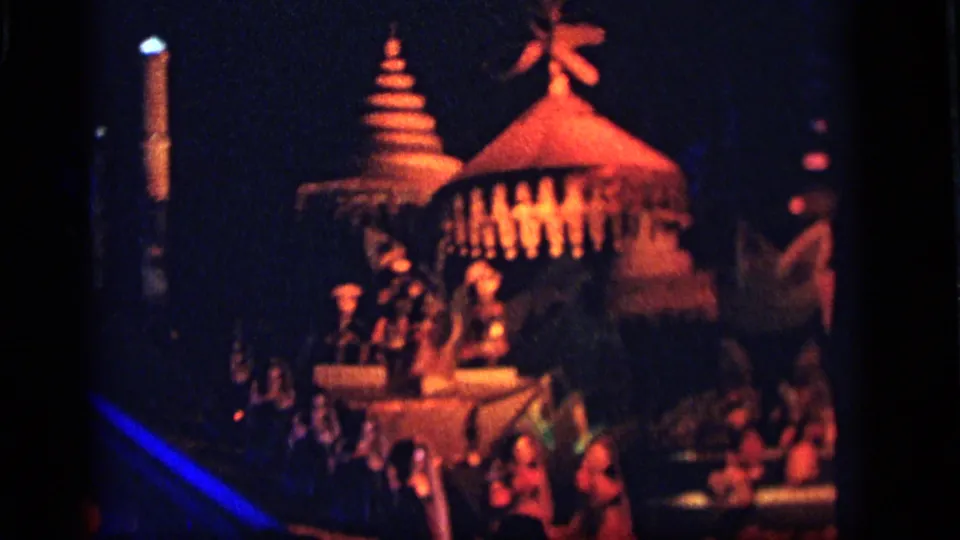 1964 Camden, New Jersey 8mm frame showing a colorful illuminated structure, small figures, and blue-orange lighting inside the ride.