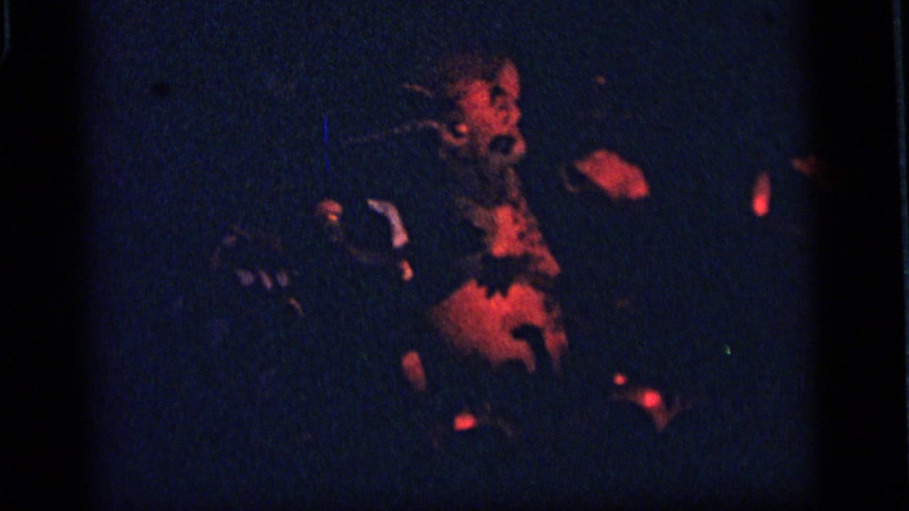 Dark amusement display with a dog-like figure lit by red and blue light.