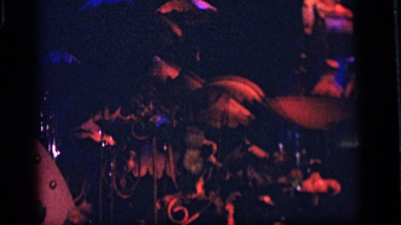 1964 Camden amusement-park scene with a partially obscured robot or puppet-like figure, decorative pieces, and red-blue lights.