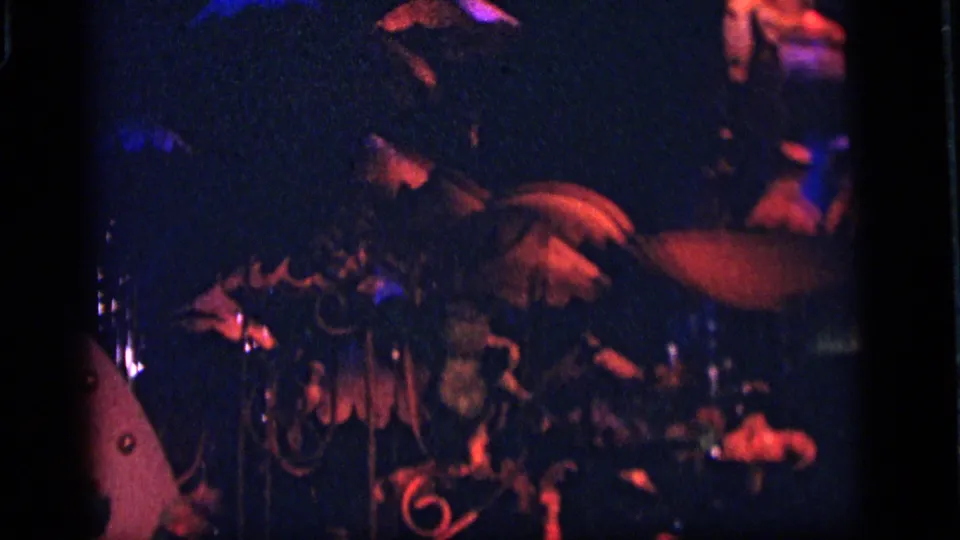 1964 Camden amusement-park scene with a partially obscured robot or puppet-like figure, decorative pieces, and red-blue lights.