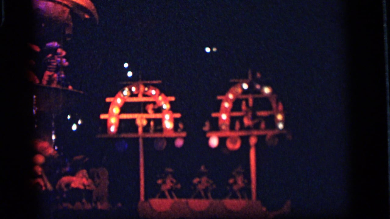 Dark indoor scene with two glowing red display arches and small figures below.