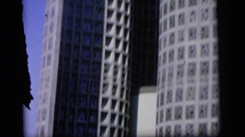 Close 8mm view of the Camden building's white lattice-patterned exterior and dark adjacent vertical structure.