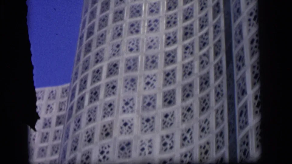 Close final frame of the Camden modern building, showing white patterned walls and blue sky in soft 8mm color.