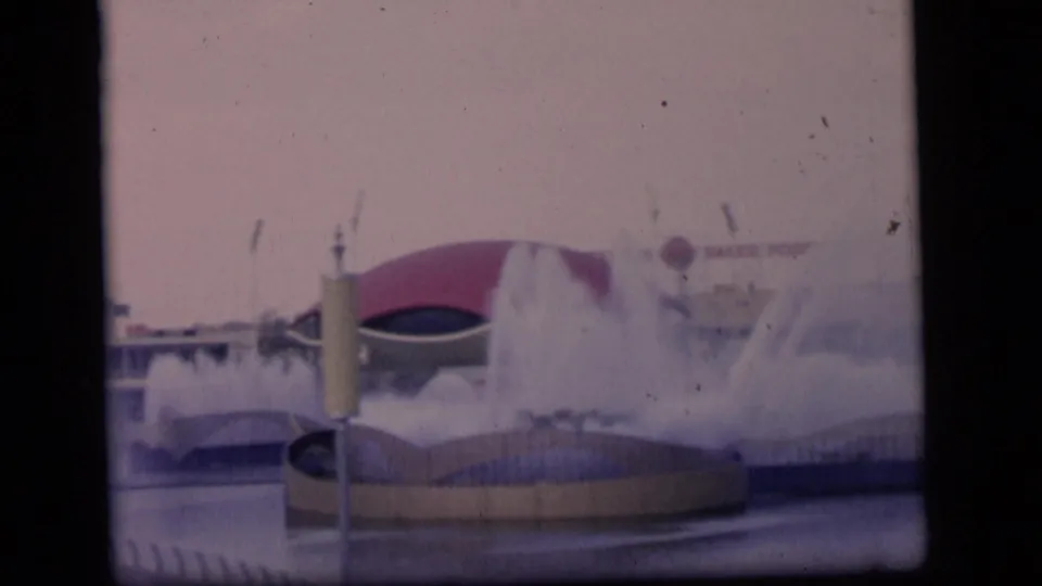 Camden 1964 8mm frame showing a grand fountain display with mist, a red-domed background structure, and low curved basins.