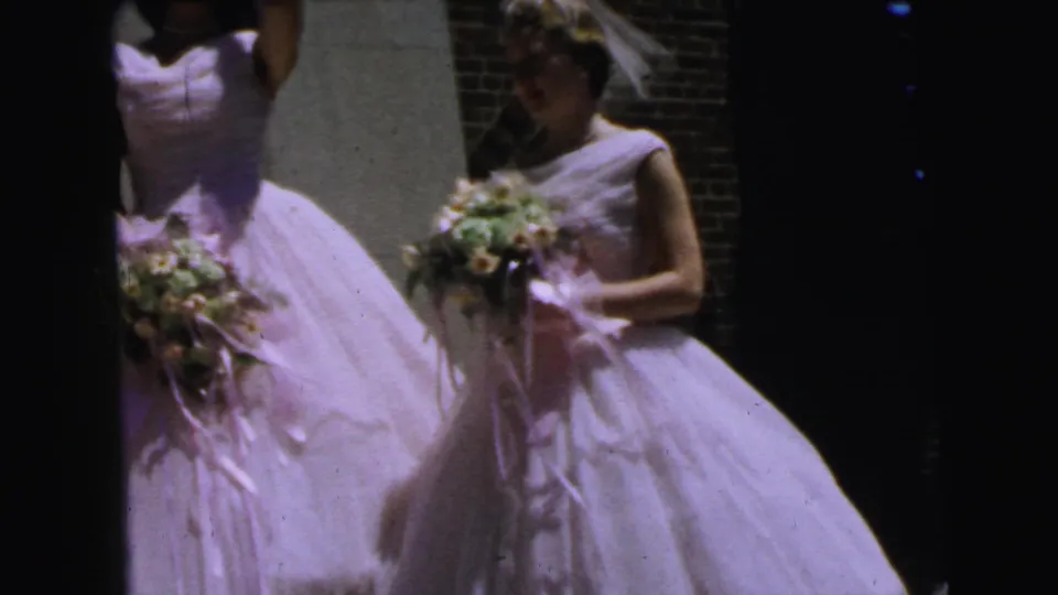 Close handheld view of bridesmaids in white gowns and veils, with bouquets and brickwork visible in the Camden wedding footage.