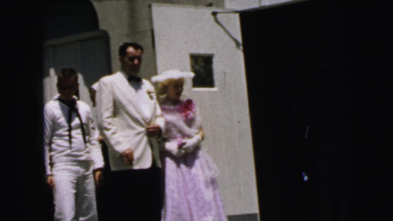 1964 Camden frame with a sailor beside a man in a white jacket and a woman in lavender formal dress.
