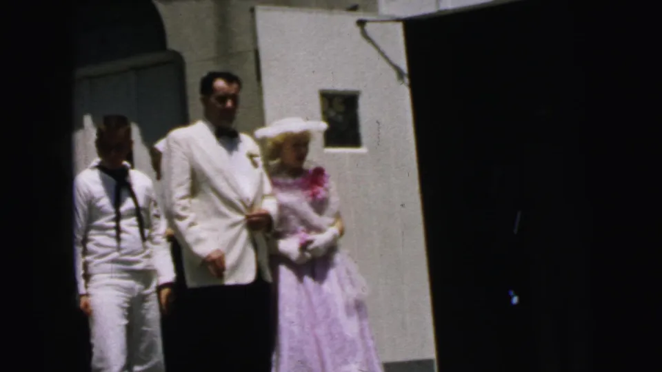 1964 Camden frame with a sailor beside a man in a white jacket and a woman in lavender formal dress.