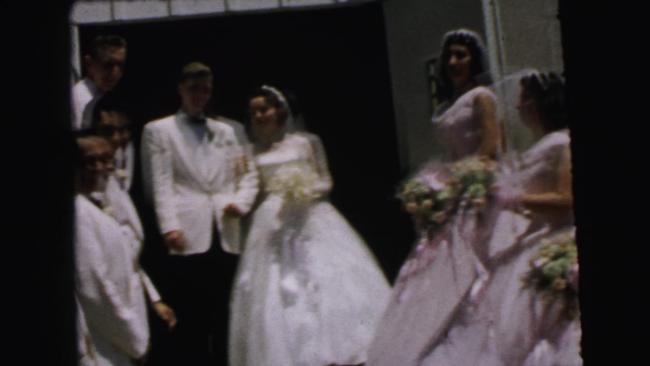 Bride and groom face the camera as bridesmaids gather beside them.